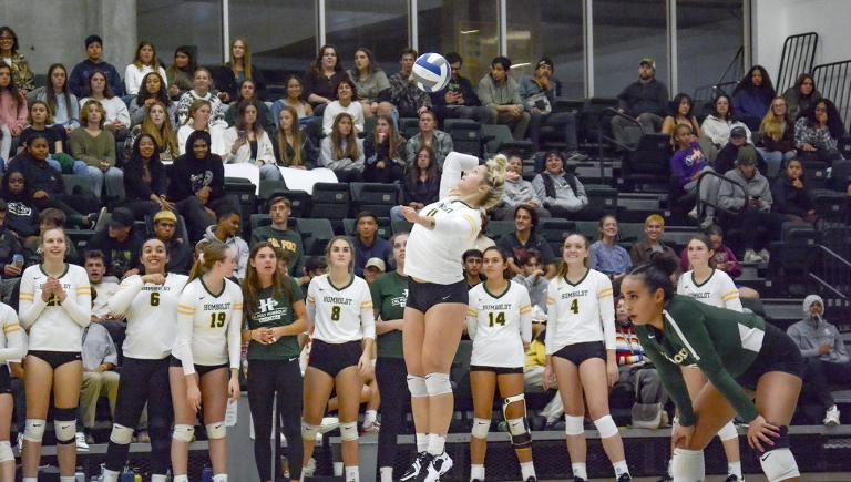 Cal Poly Humboldt volleyball players in a match in Lumberjack Arena