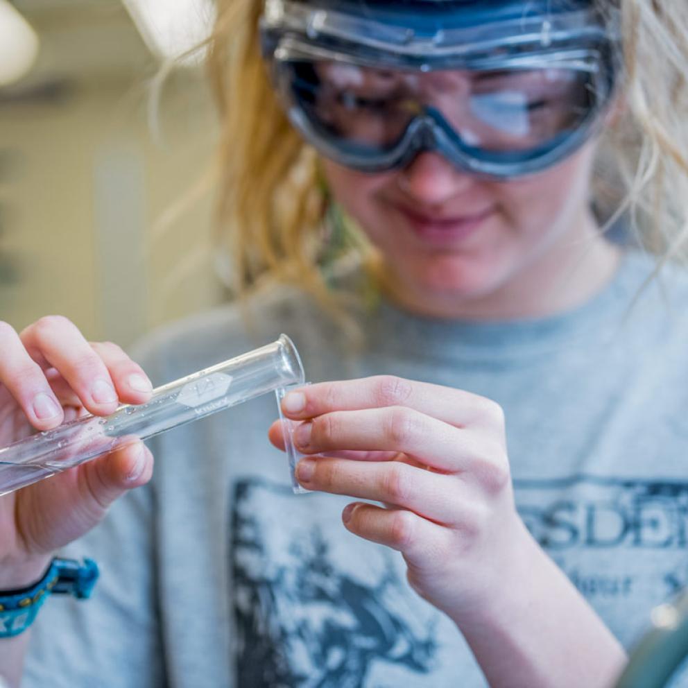a blond student working in the chemistry lab