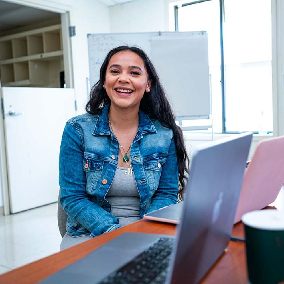 Student sitting at table with laptops