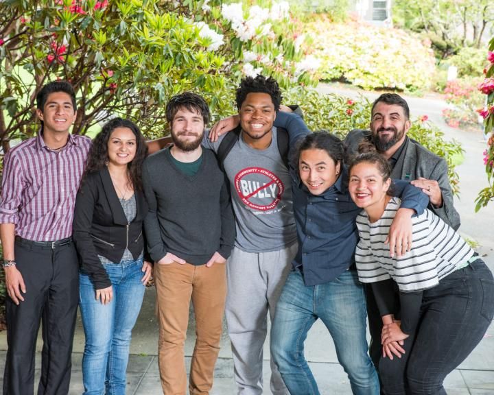 Group of students smiling at the camera hugging