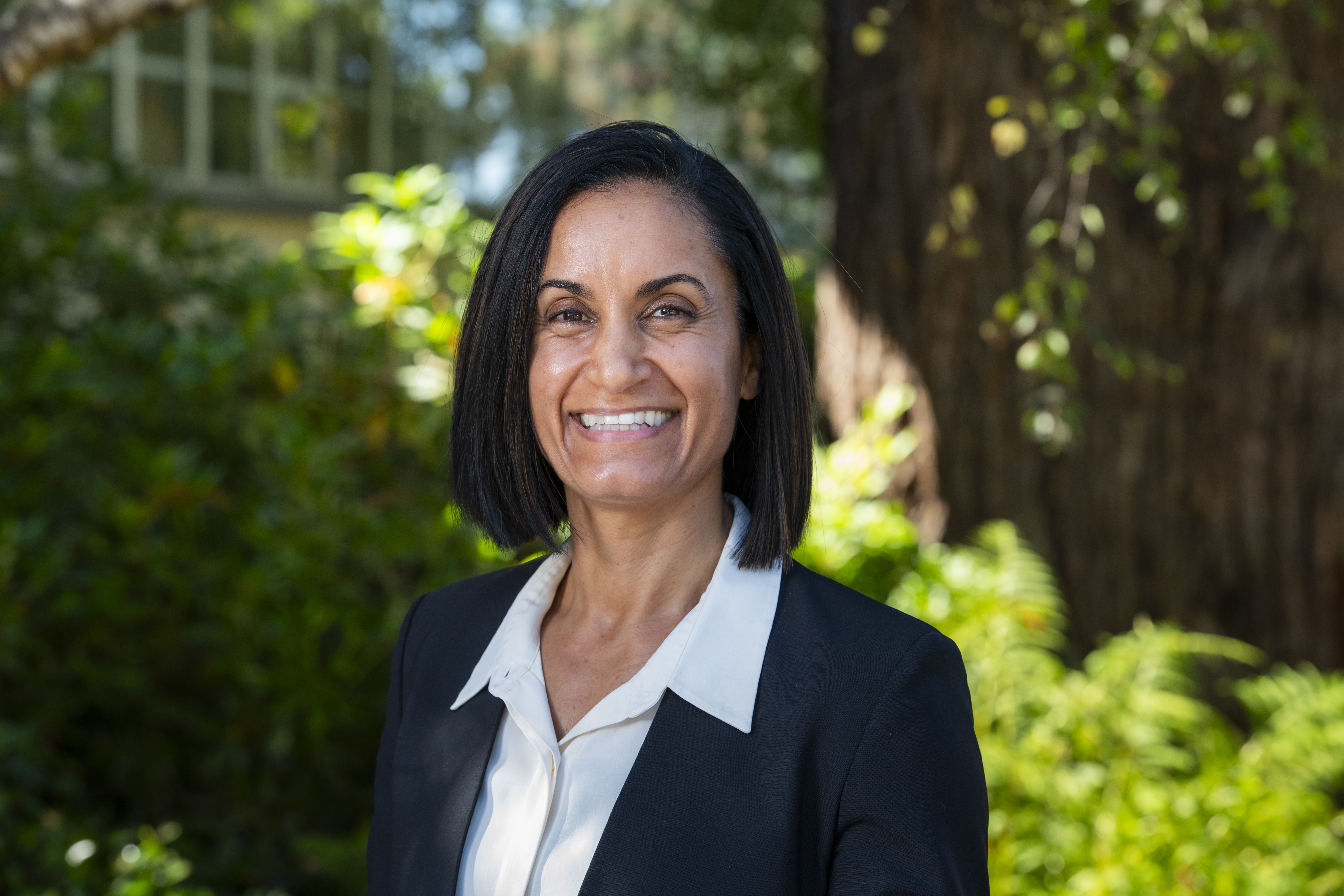 Portrait of Dr. Shawna Young in front of Siemens Hall and redwoods