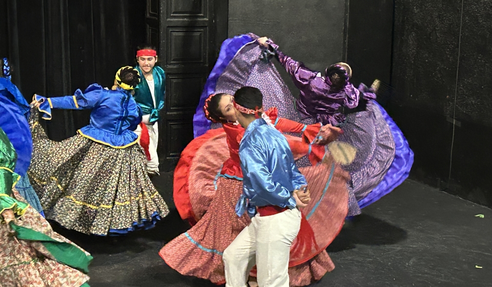 people in large colorful outfits dancing