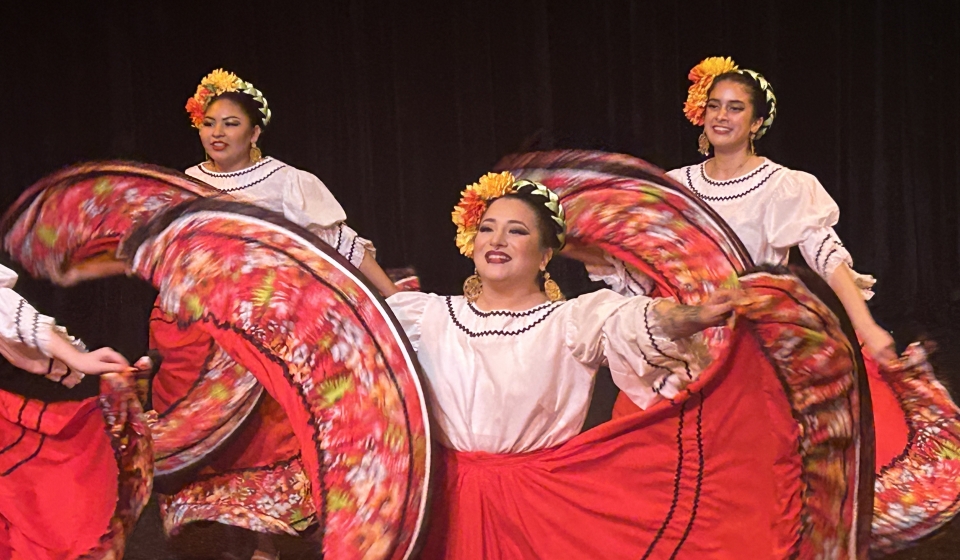 people in bright red skirts with white tops dancing