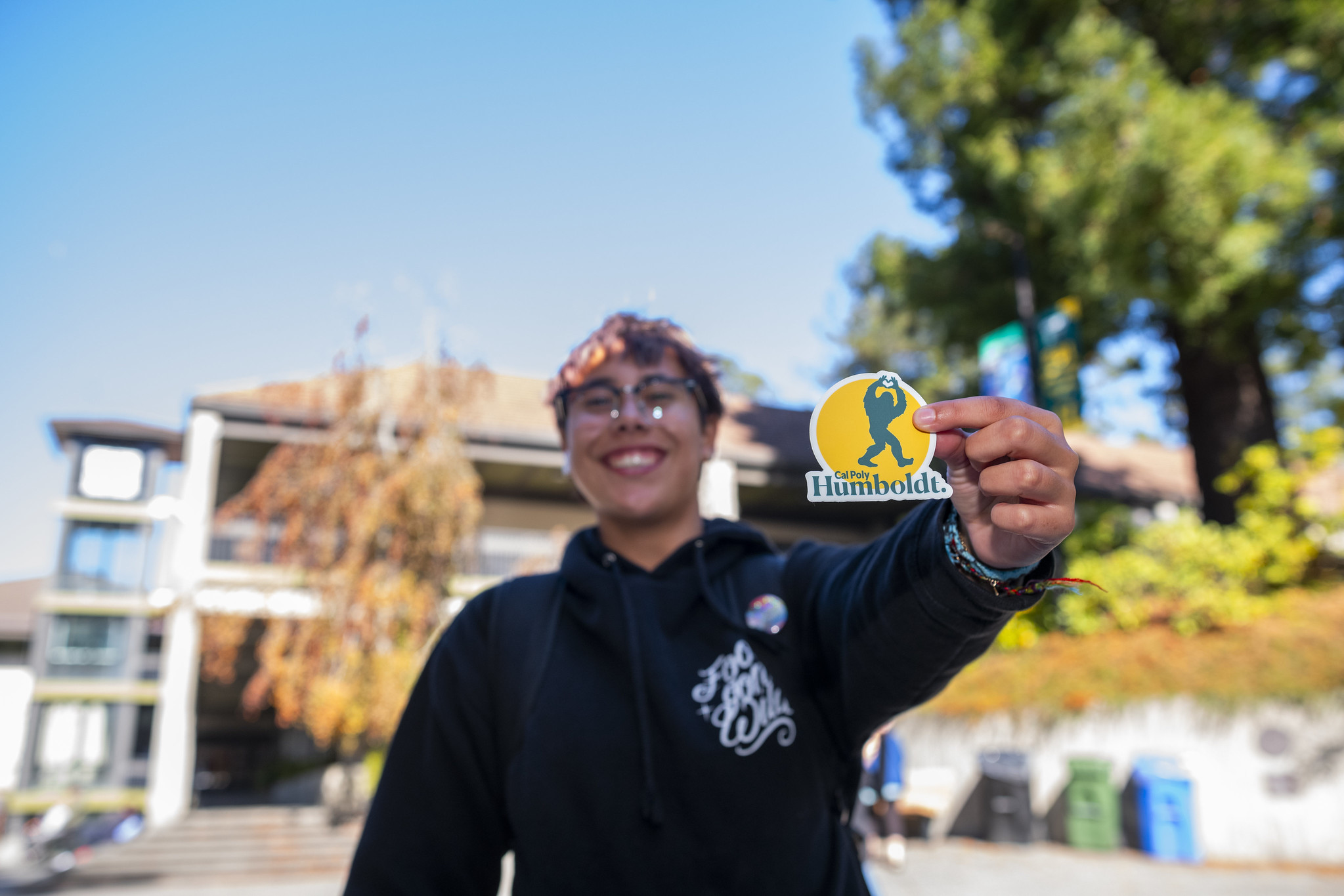 Student Holding Up Cal Poly Humboldt Sasquatch Sticker