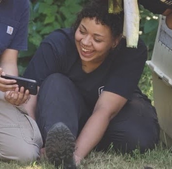 Namae sitting in grass, smiling.