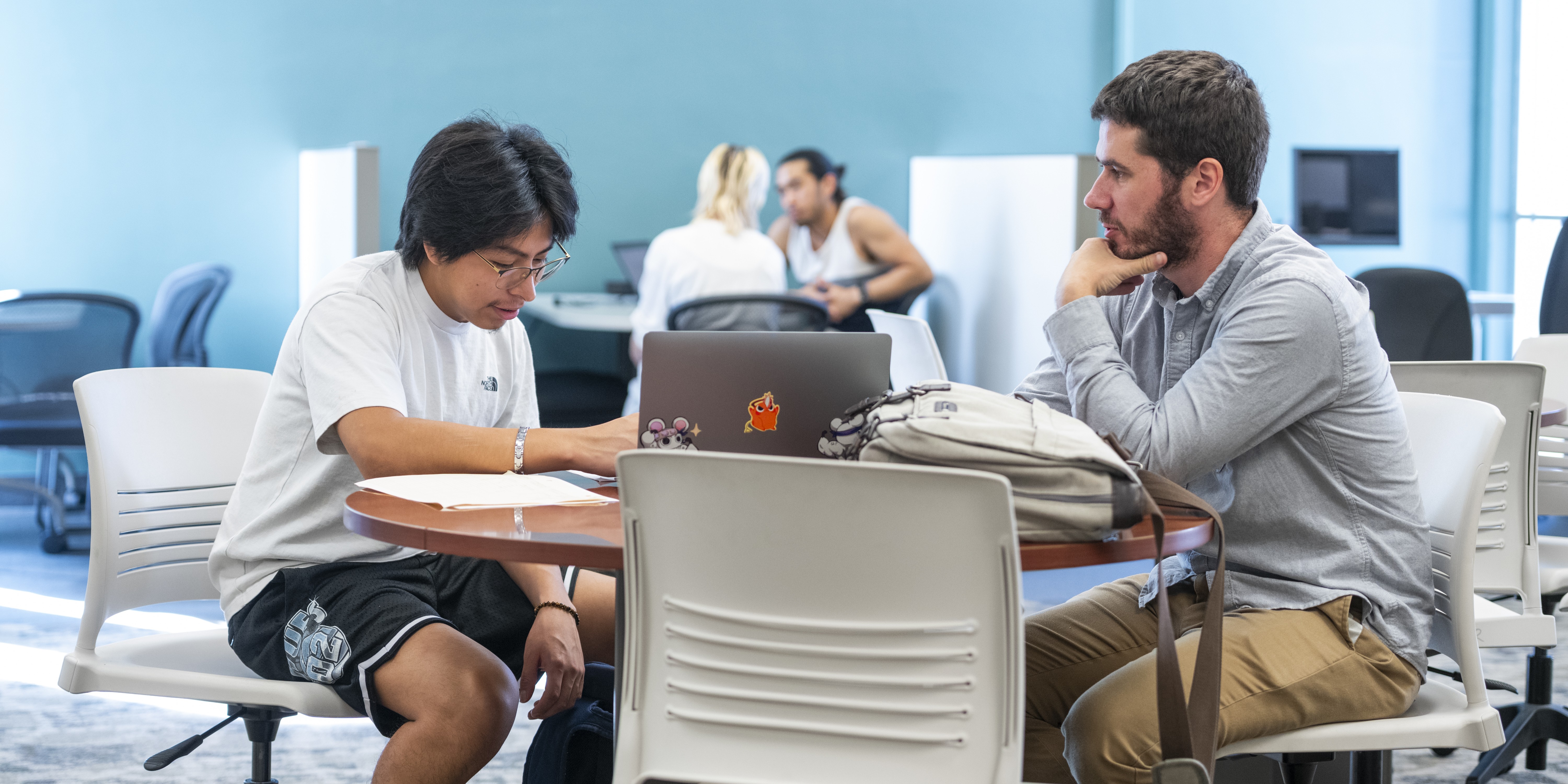 Student working on paper with Learning Center Leader
