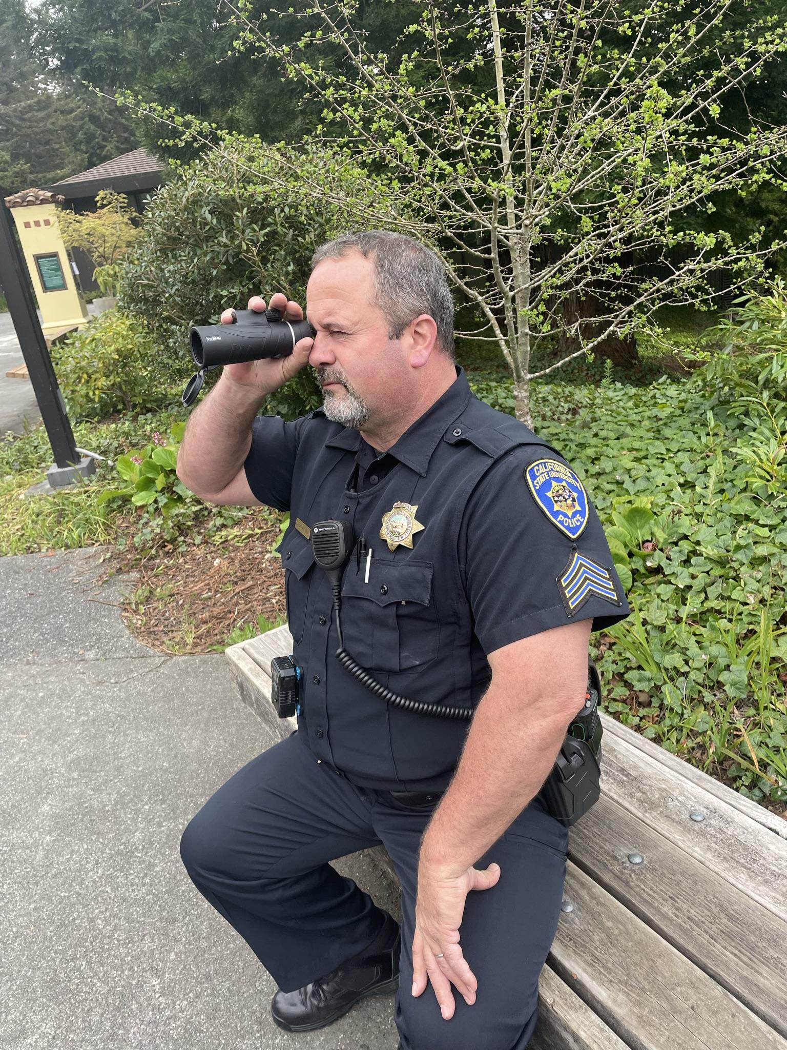 Cop sitting on bench with monoculure