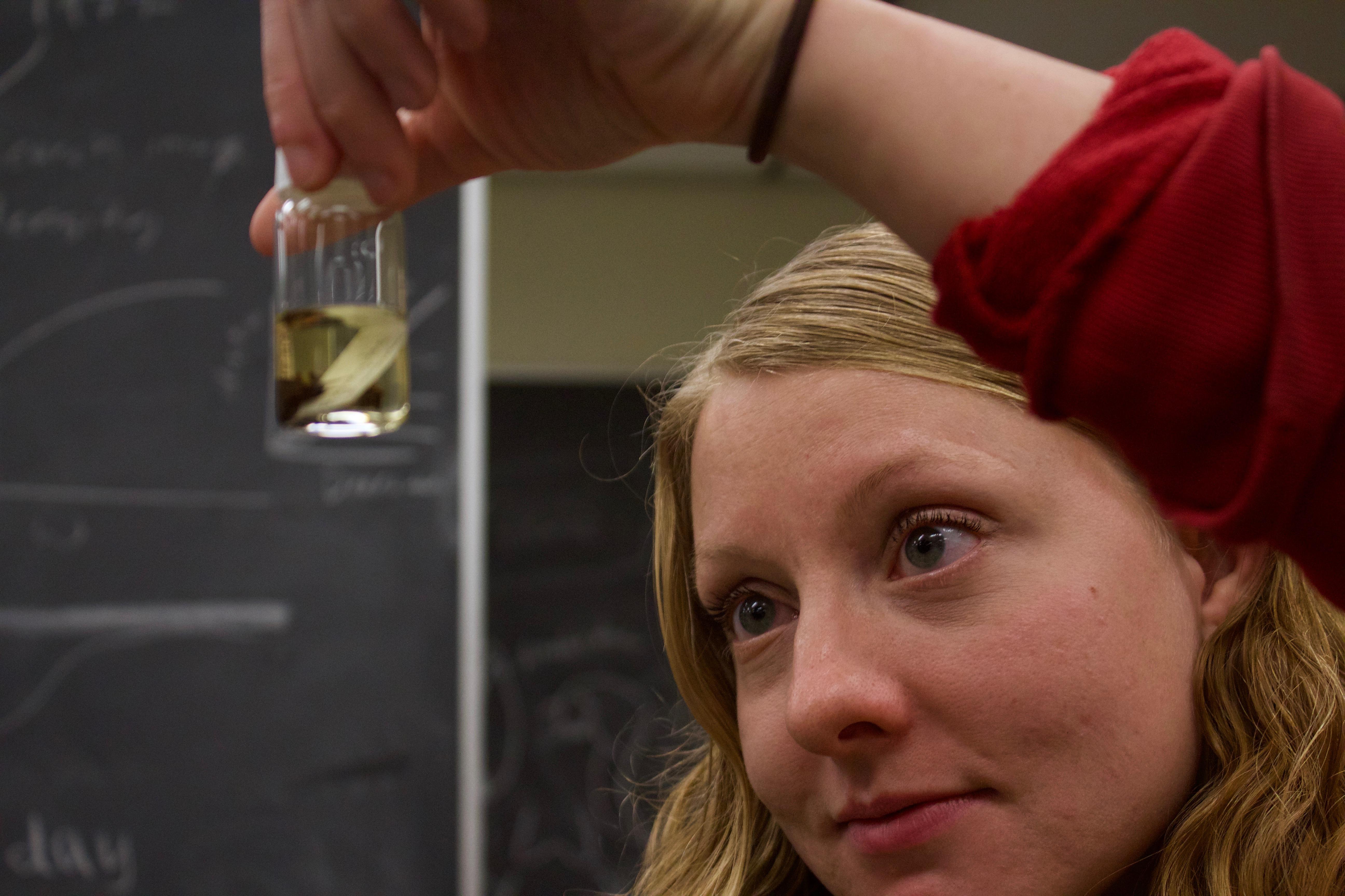 Humboldt undergraduate Katherine Stonecypher examines an invertebrate in a vial in the River Institute laboratory