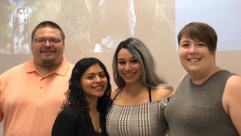 four people standing arm in arm