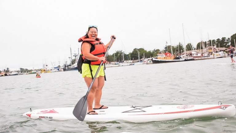 One person standing on a paddleboard paddling on the Humboldt Bay.