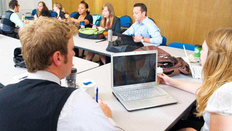 Students around a square table in a classroom