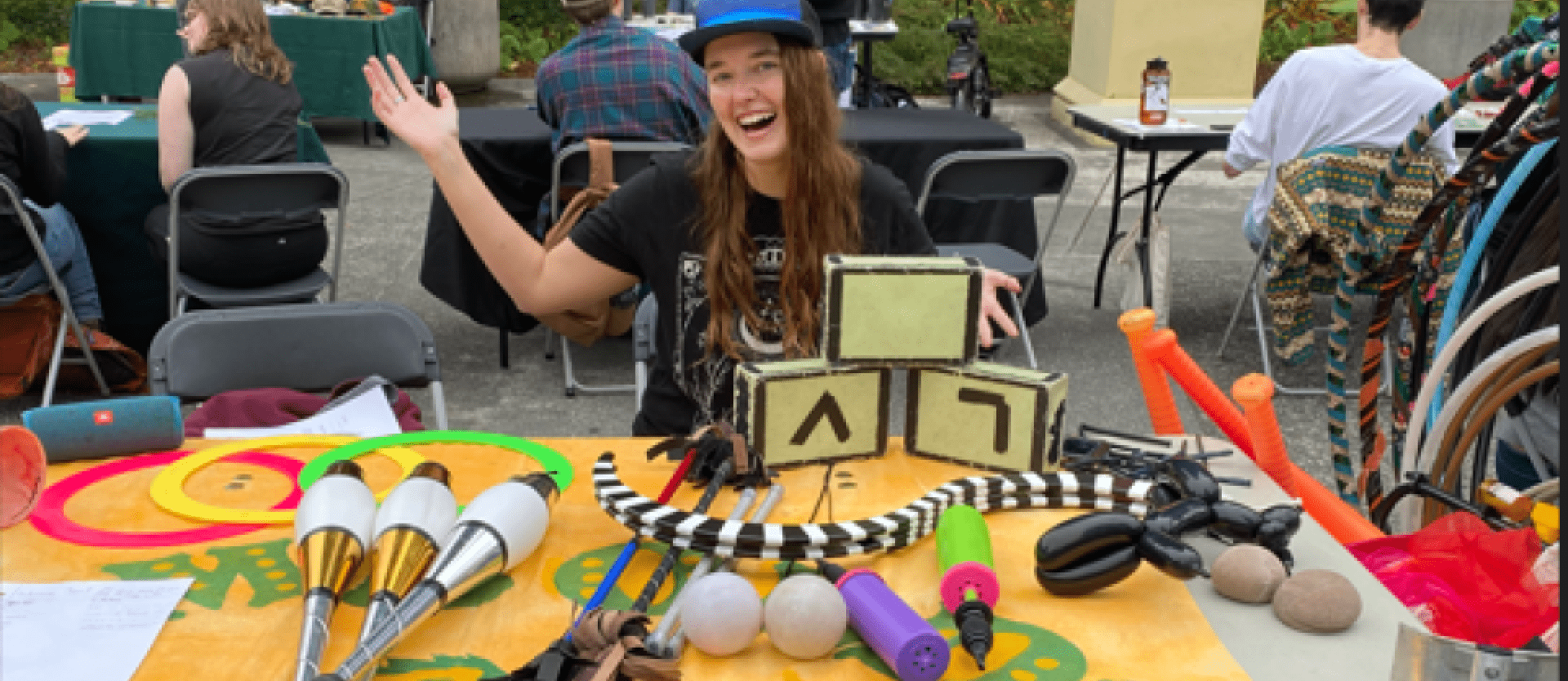 student at a table with a bunch of circus equipment