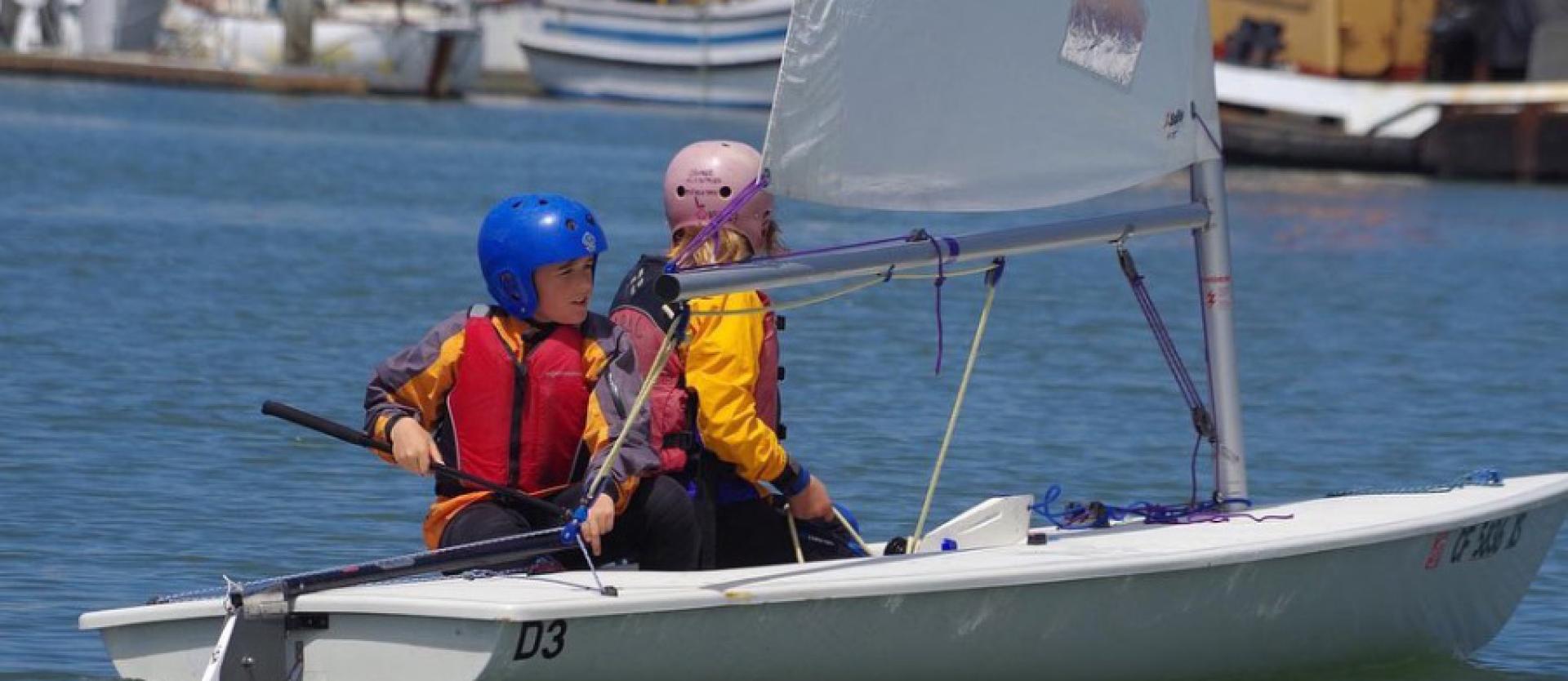 2 youth on a sailboat practicing skills