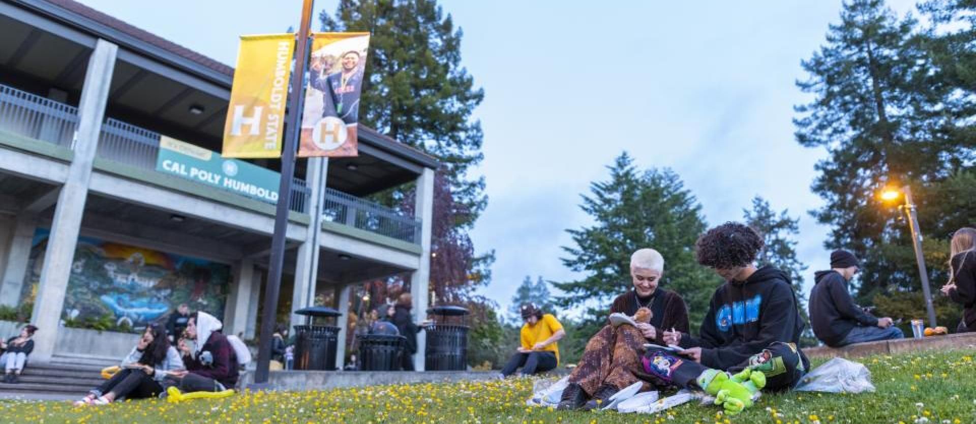 Gutswurrak front with students sitting in grass