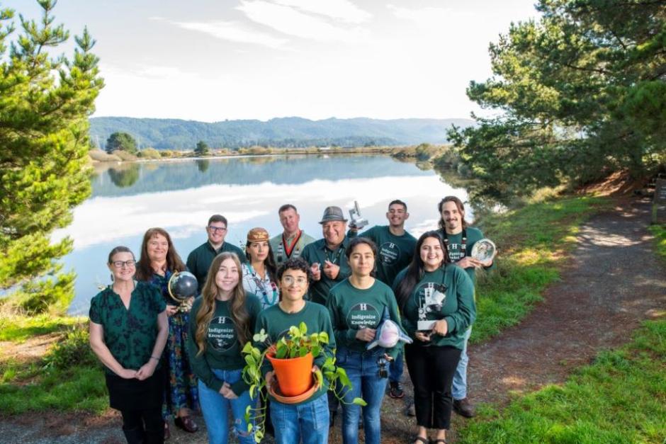 members of INRSEP gather in front of a body of water holding plants