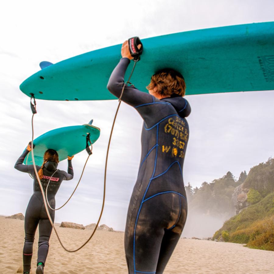 People with surfboards on heads at beach