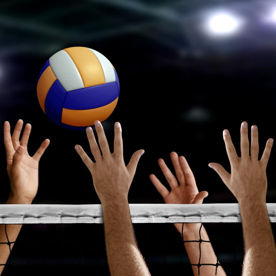 Volleyball players hands attempting to block a volleyball