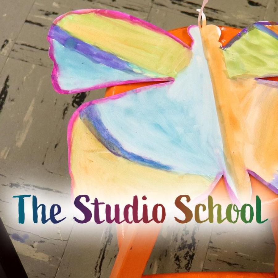 Watercolored paper butterflies drying on wooden stools in the art room