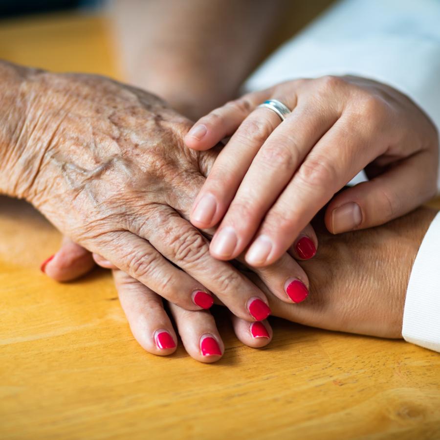 older and younger woman's hands touching