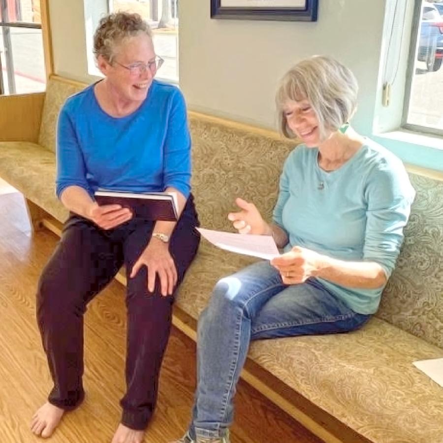 Two women holding scripts practicing their lines