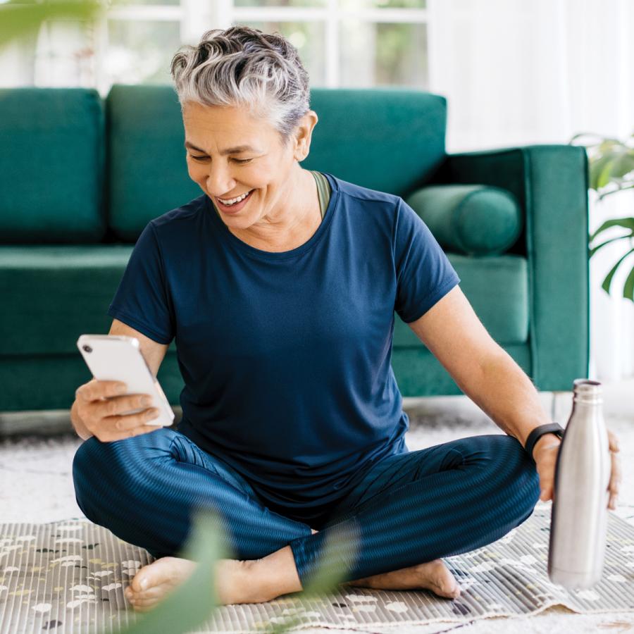 Woman checking her health app on her phone, after exercising Woman checking her health app on her phone, after exercising
