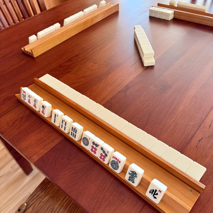 Racks of mahjong tiles on a table Racks of mahjong tiles on a table