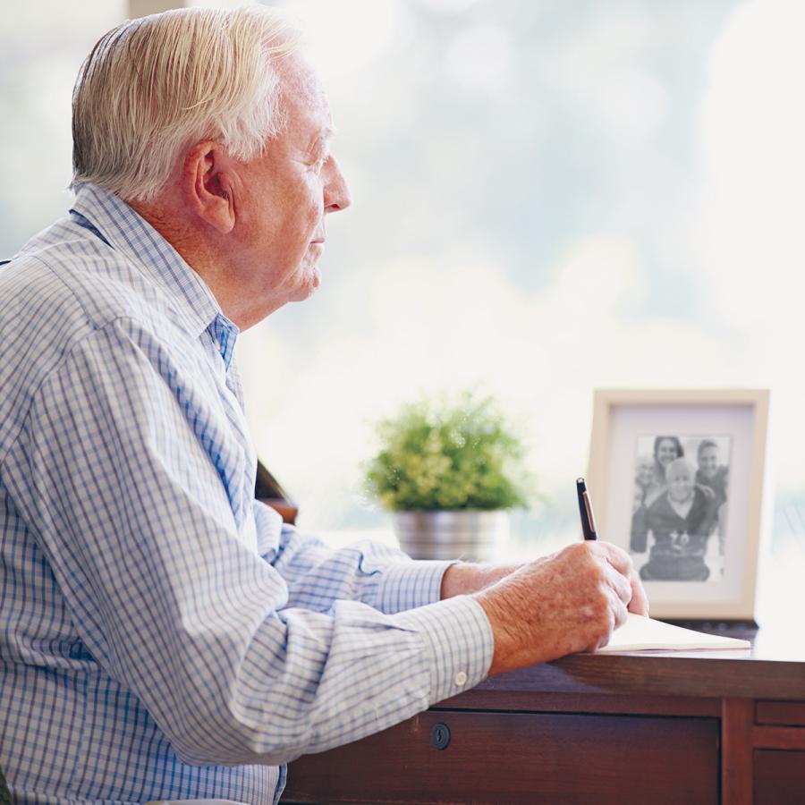 Older man writing at his desk Older man writing at his desk