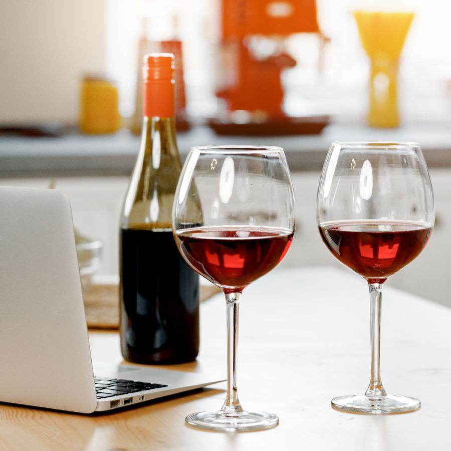 Wine glasses and bottle, next to notebook computer on kitchen counter Wine glasses and bottle, next to notebook computer on kitchen counter