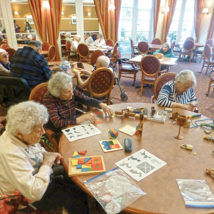 Older adults playing with various games at tables Older adults playing with various games at tables