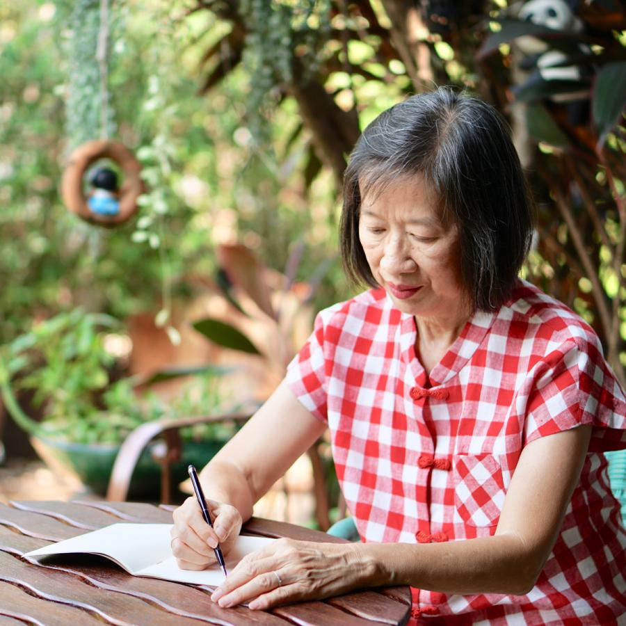 woman writing in her journal, while in her garden woman writing in her journal, while in her garden