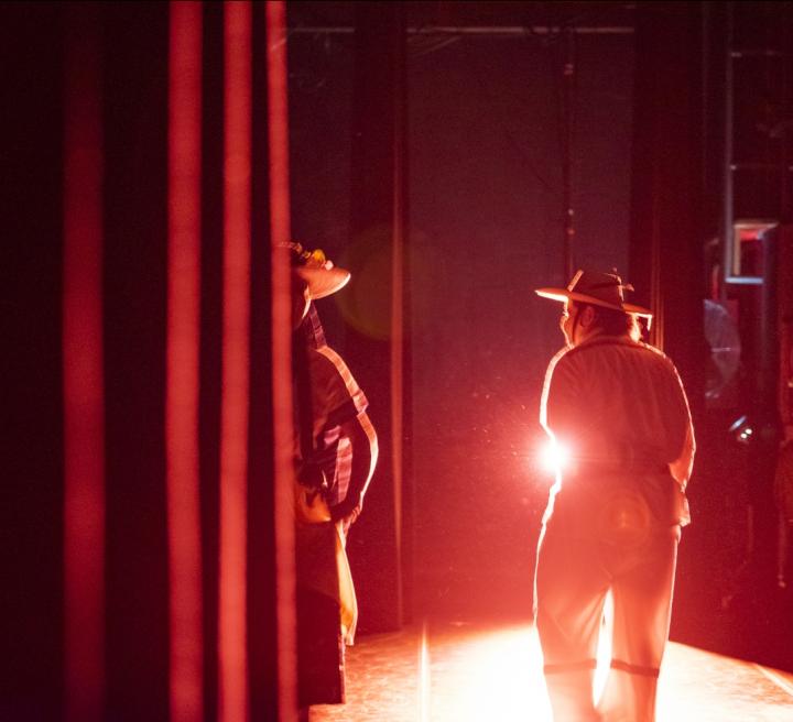 a person in the theatre with a light behind them