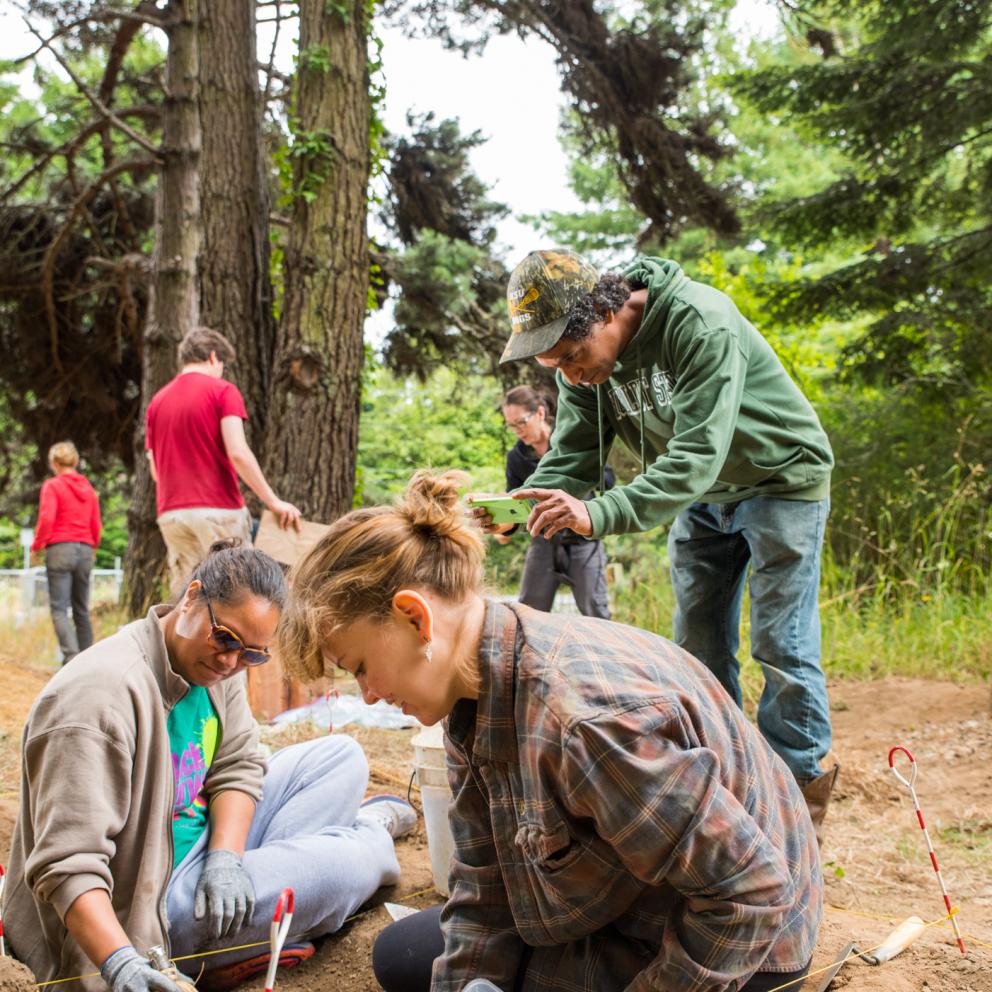 Students uncovering things in the dirt