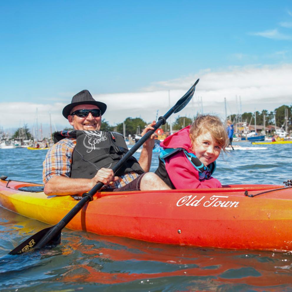 Man on a kayak with a child