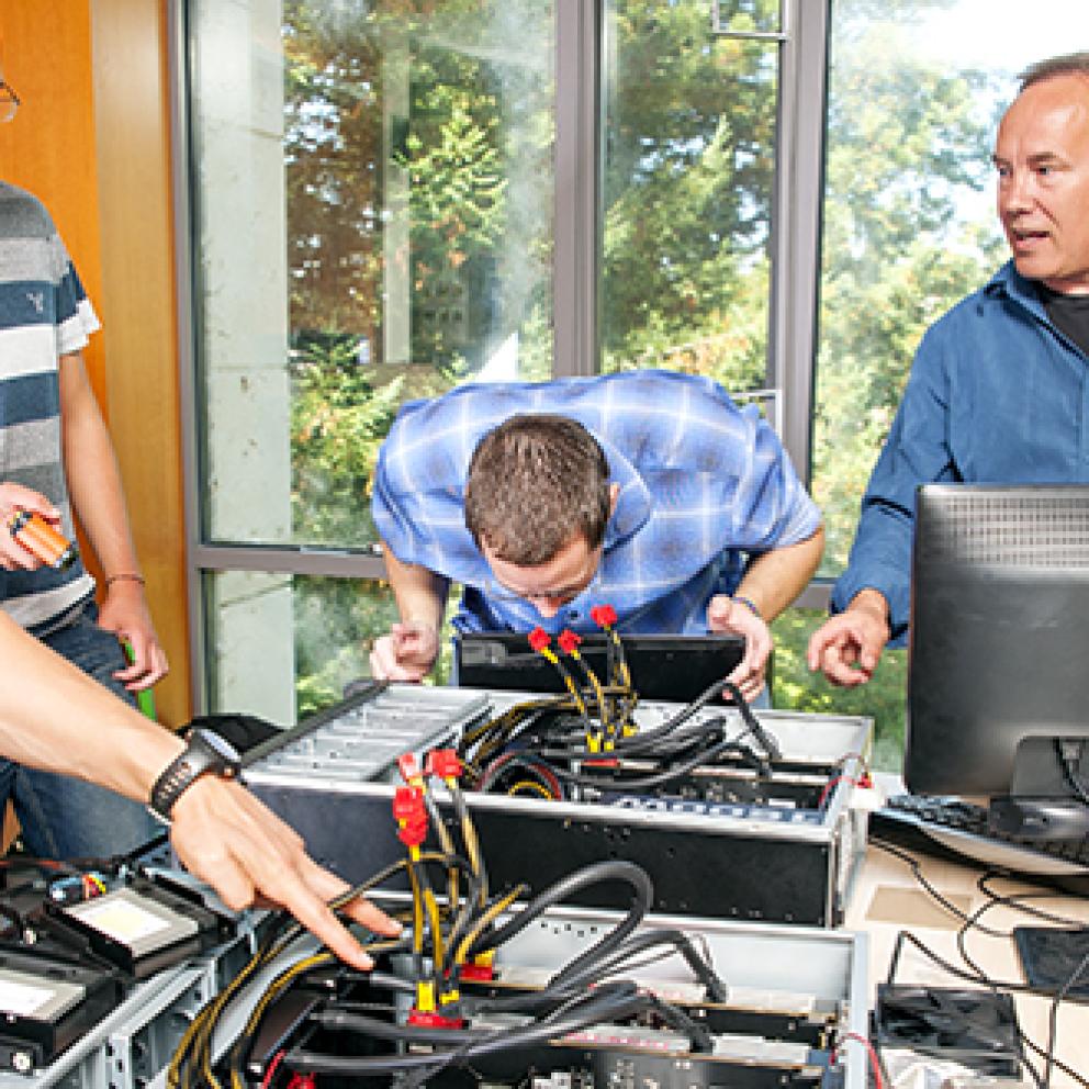 Super computer with students standing aroud it 