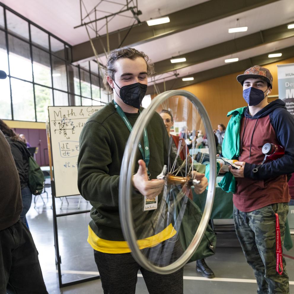 Students holding a wheel at a presentation / conference