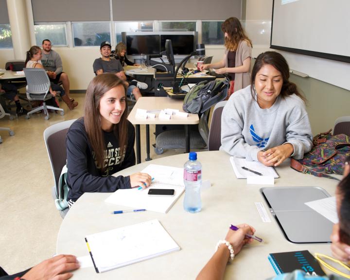 two students sitting at a table smiling