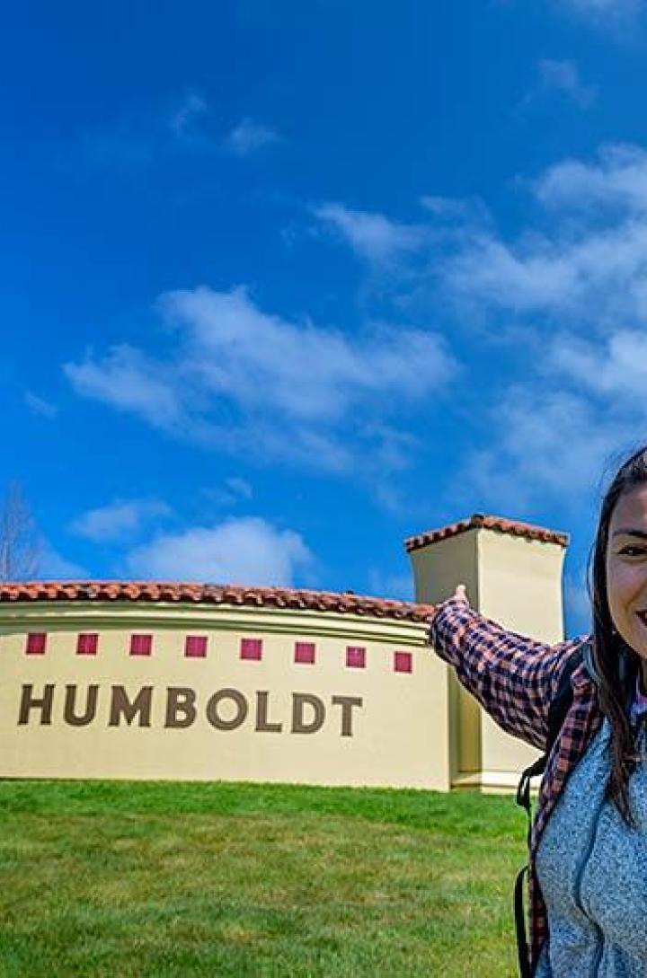 Student pointing at campus entrance