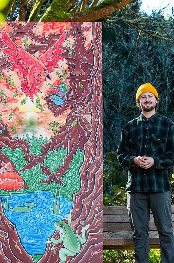 Student posing with mural