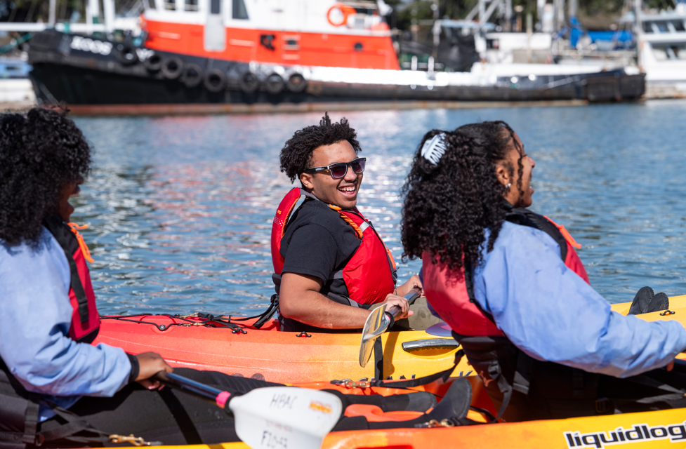 Umoja Students paddling and laughing on Humboldt Bay